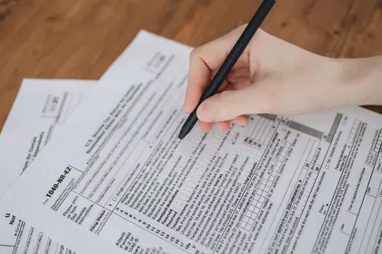 Mão preenchendo documento técnico